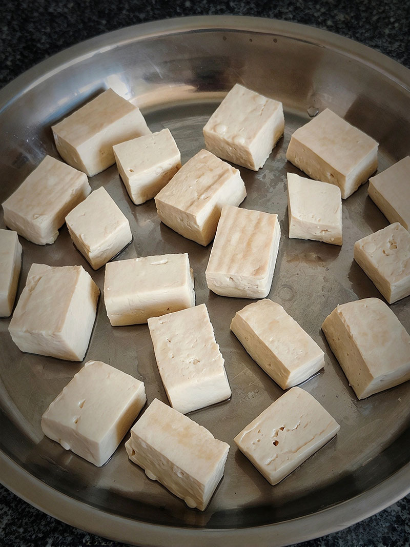 Steaming firm tofu cubes in a bamboo steamer for 5 minutes for homemade mao doufu
