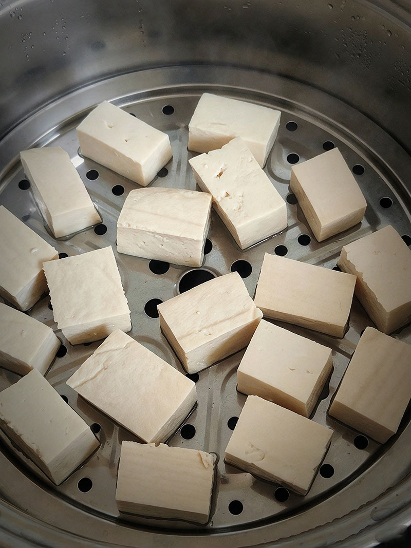 Cooling down steamed firm tofu cubes on a rack for making mao doufu